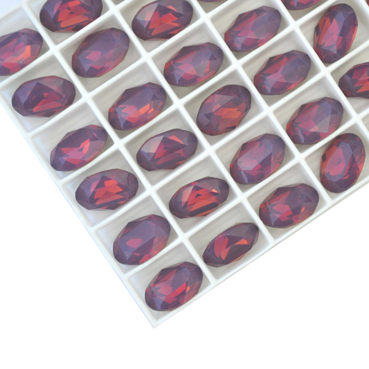 Oval shape faceted Austrian crystal rhinestones in the color Cyclamen Opal displayed on a white background.