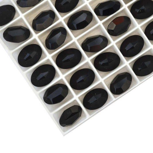 Oval shape faceted Austrian crystal rhinestones in the color Jet displayed on a white background.