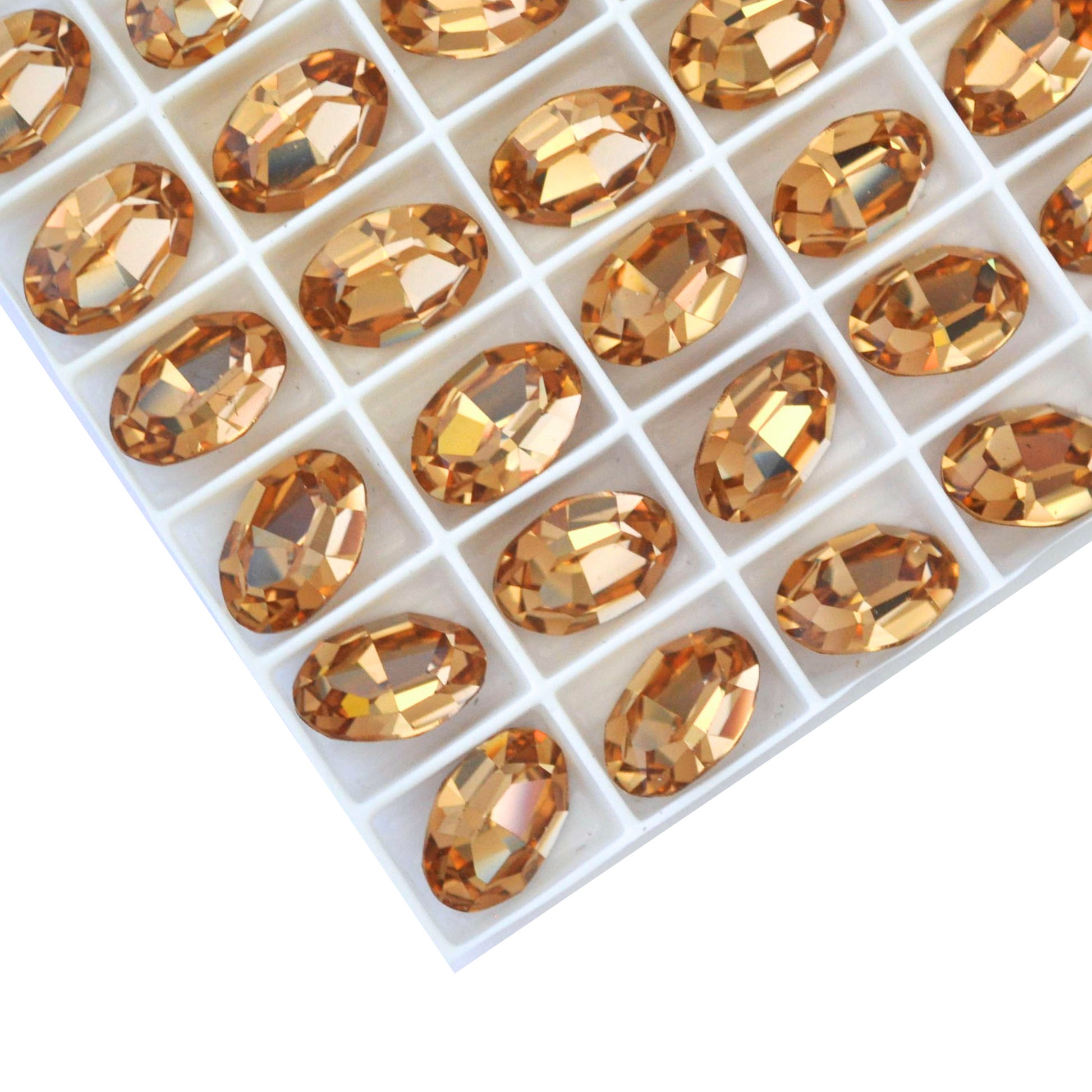 Oval shape faceted Austrian crystal rhinestones in the color Light Colorado Topaz displayed on a white background.