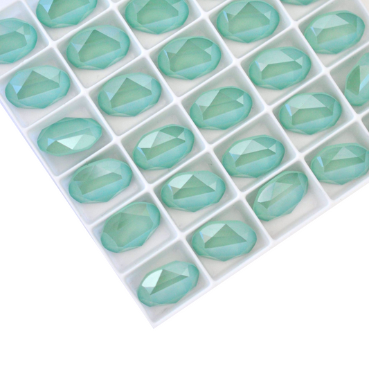 Oval shape faceted Austrian crystal rhinestones in the color Mint Green displayed on a white background.
