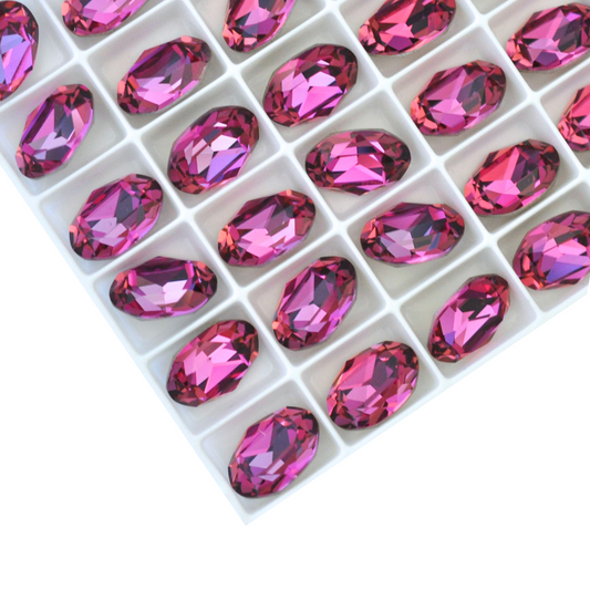 Oval shape faceted Austrian crystal rhinestones in the color Rose Vitrail Light displayed on a white background.