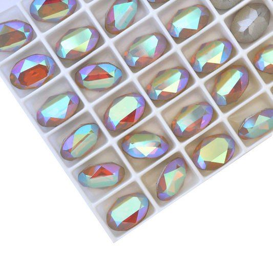 Oval shape faceted Austrian crystal rhinestones in the color Sand Opal AB displayed on a white background.