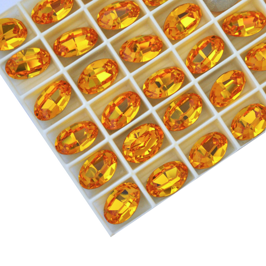 Oval shape faceted Austrian crystal rhinestones in the color Sunflower displayed on a white background.