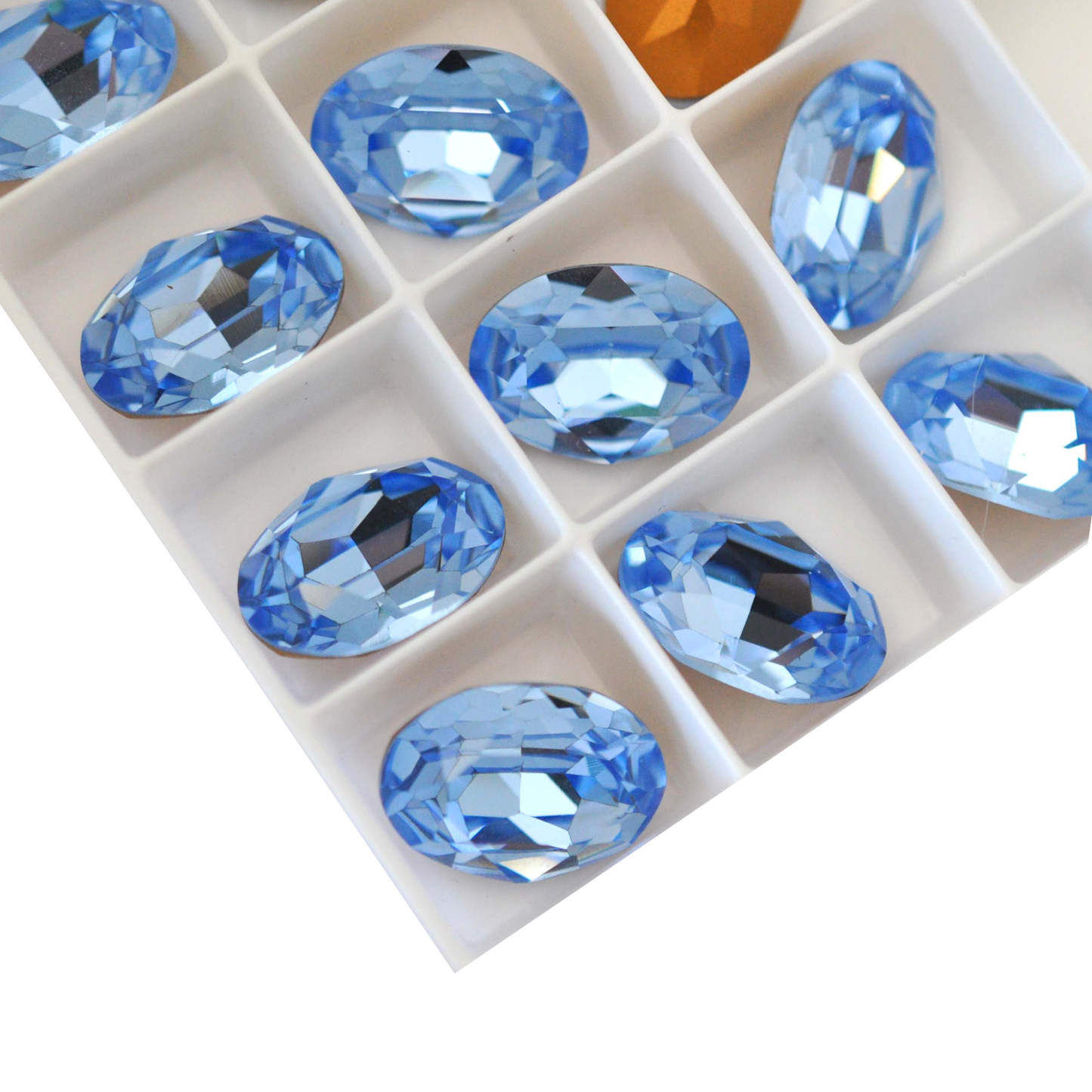 Oval shape faceted Austrian crystal rhinestones in the color Light Sapphire displayed on a white background.