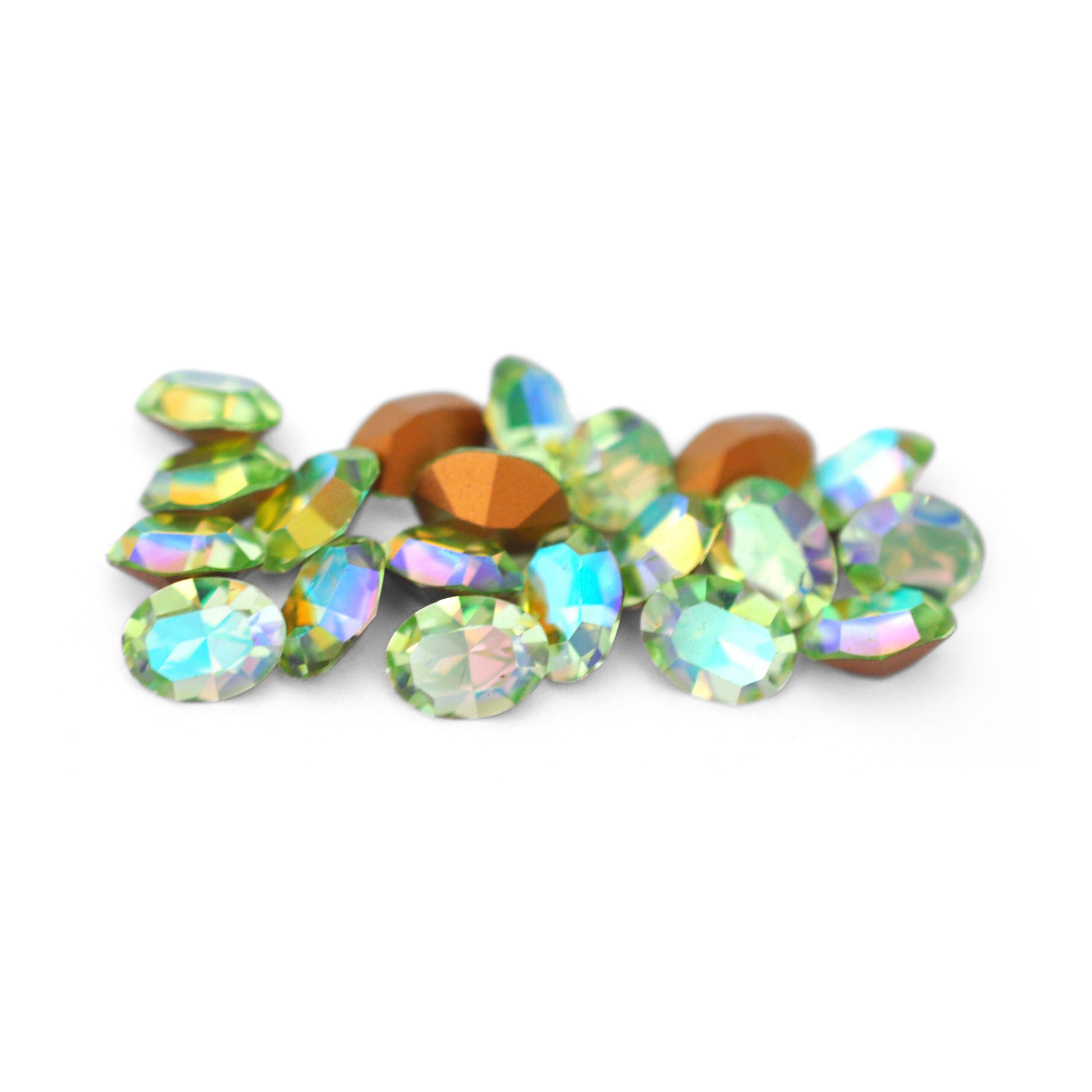 Oval shaped faceted Austrian crystal rhinestones in the color Chrysolite AB displayed on a white background.