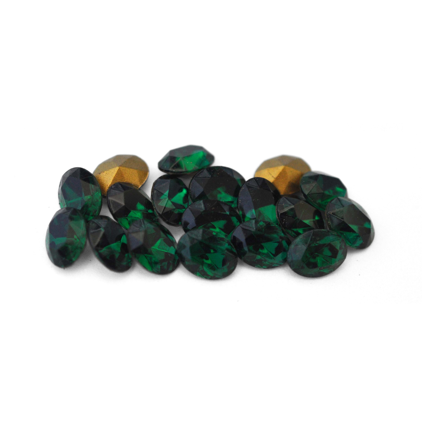 Oval shaped faceted Austrian crystal rhinestones in the color Emerald displayed on a white background.