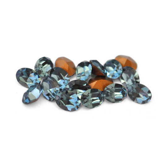 Oval shaped faceted Austrian crystal rhinestones in the color Indian Sapphire displayed on a white background.
