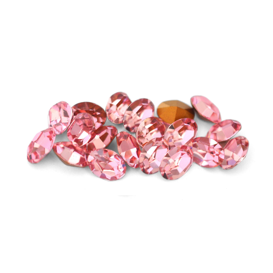 Oval shaped faceted Austrian crystal rhinestones in the color Light Rose displayed on a white background.