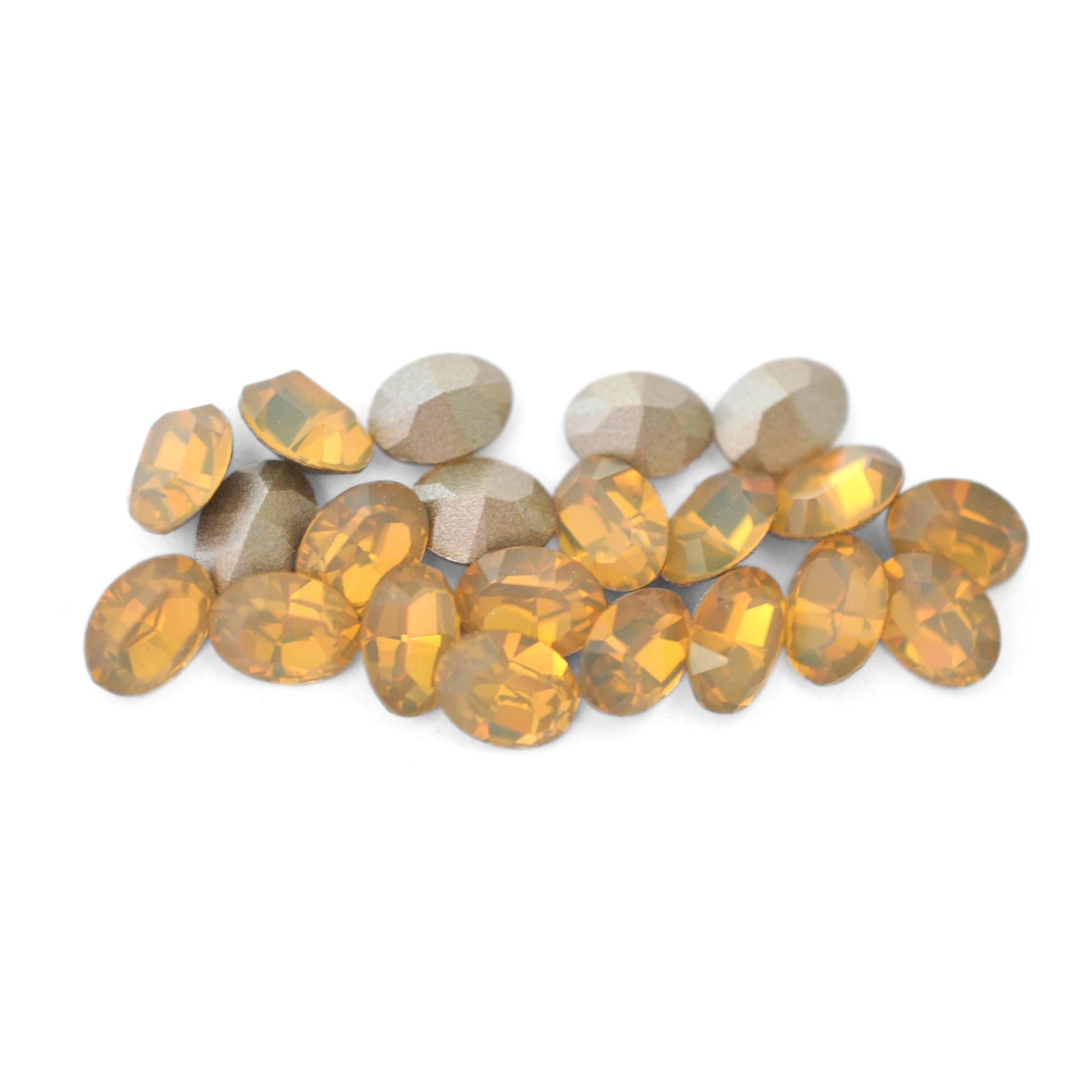 Oval shaped faceted Austrian crystal rhinestones in the color Sand Opal displayed on a white background.
