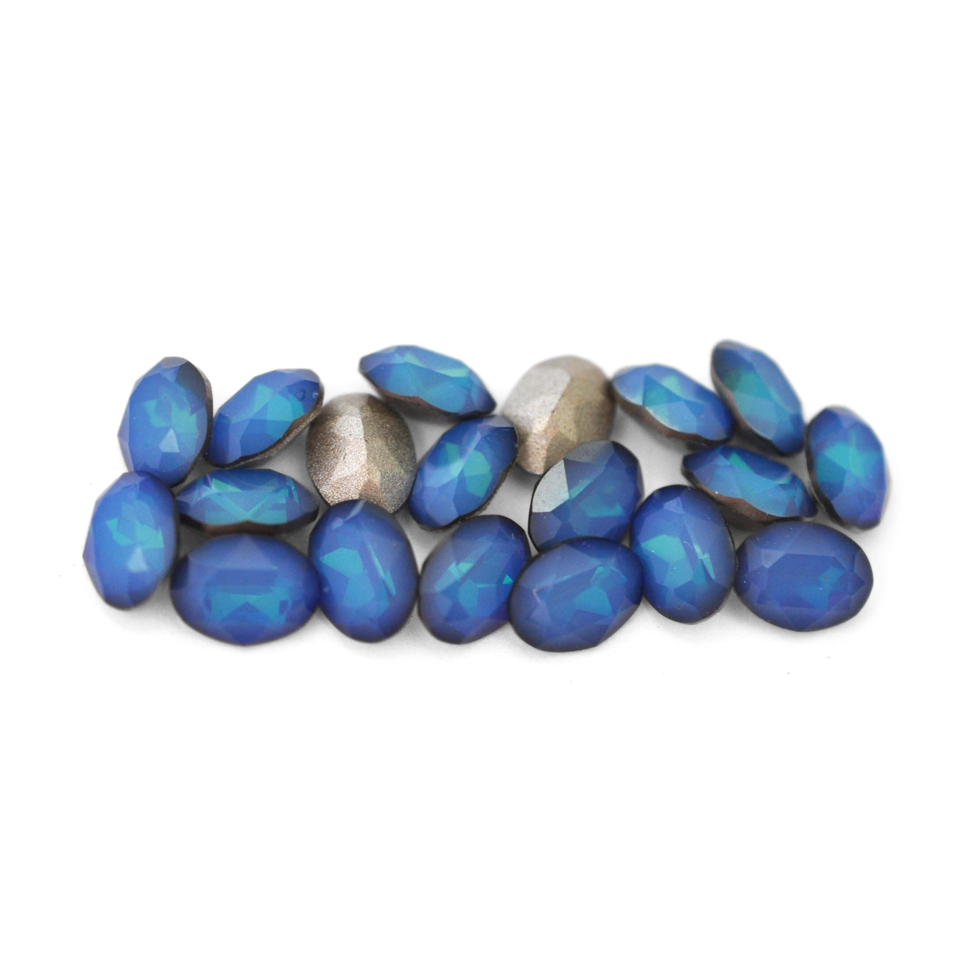 Oval shaped faceted Austrian crystal rhinestones in the color White Opal Sky Blue displayed on a white background.