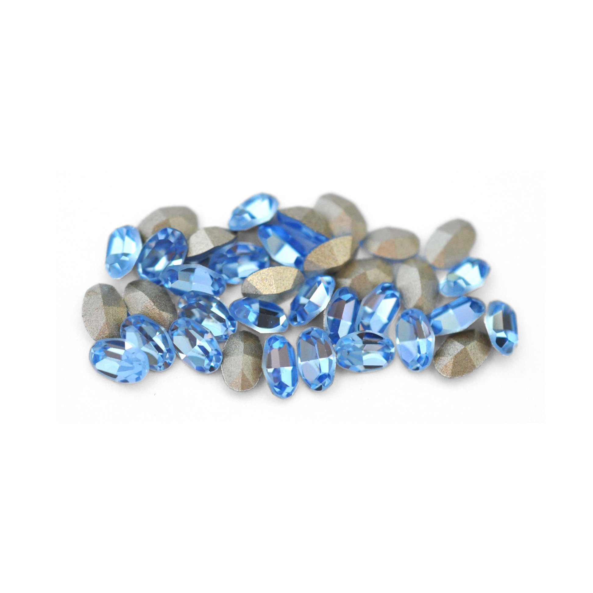Oval shaped faceted Austrian crystal rhinestones in the color Light Sapphire displayed on a white background.