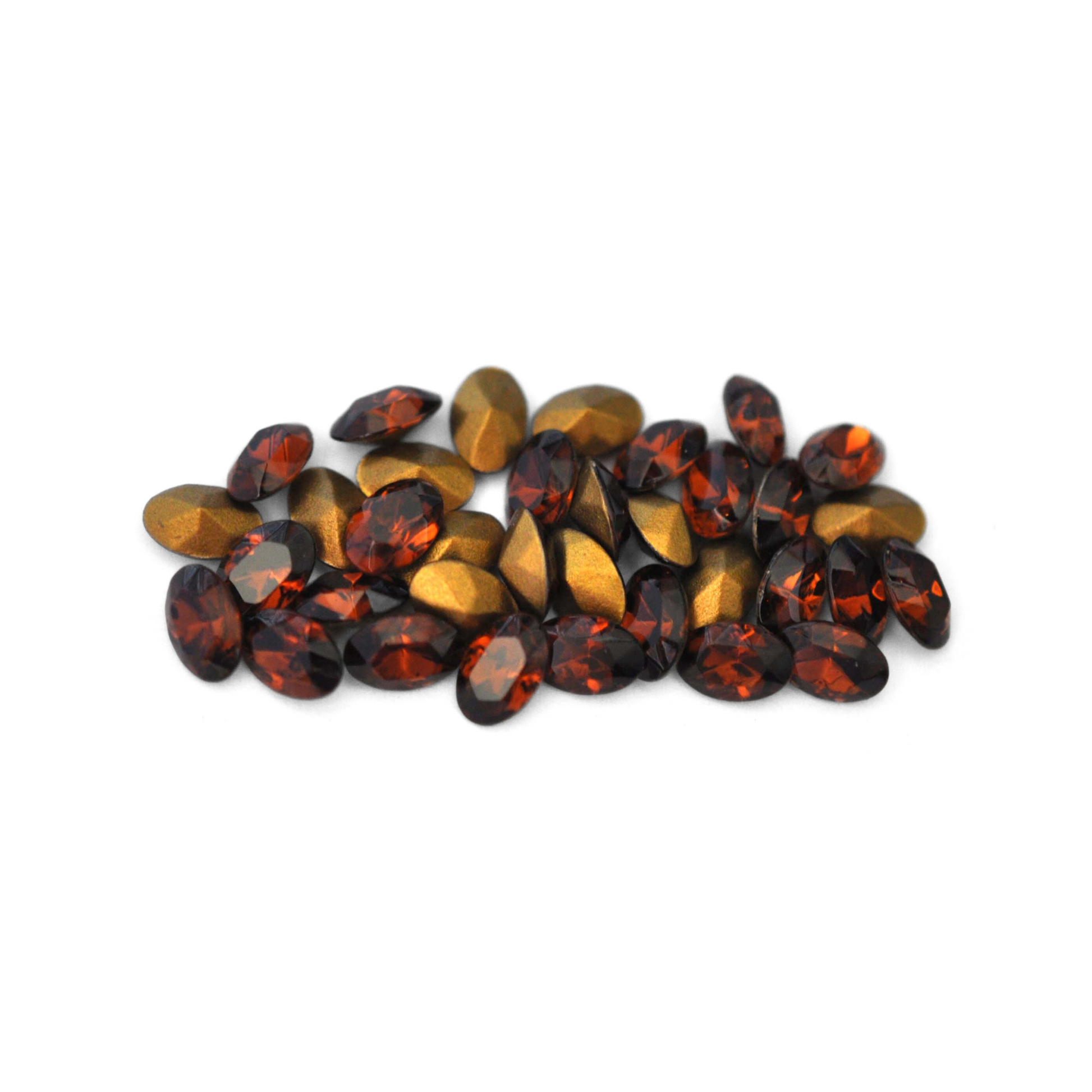 Oval shaped faceted Austrian crystal rhinestones in the color Smoked Topaz displayed on a white background.