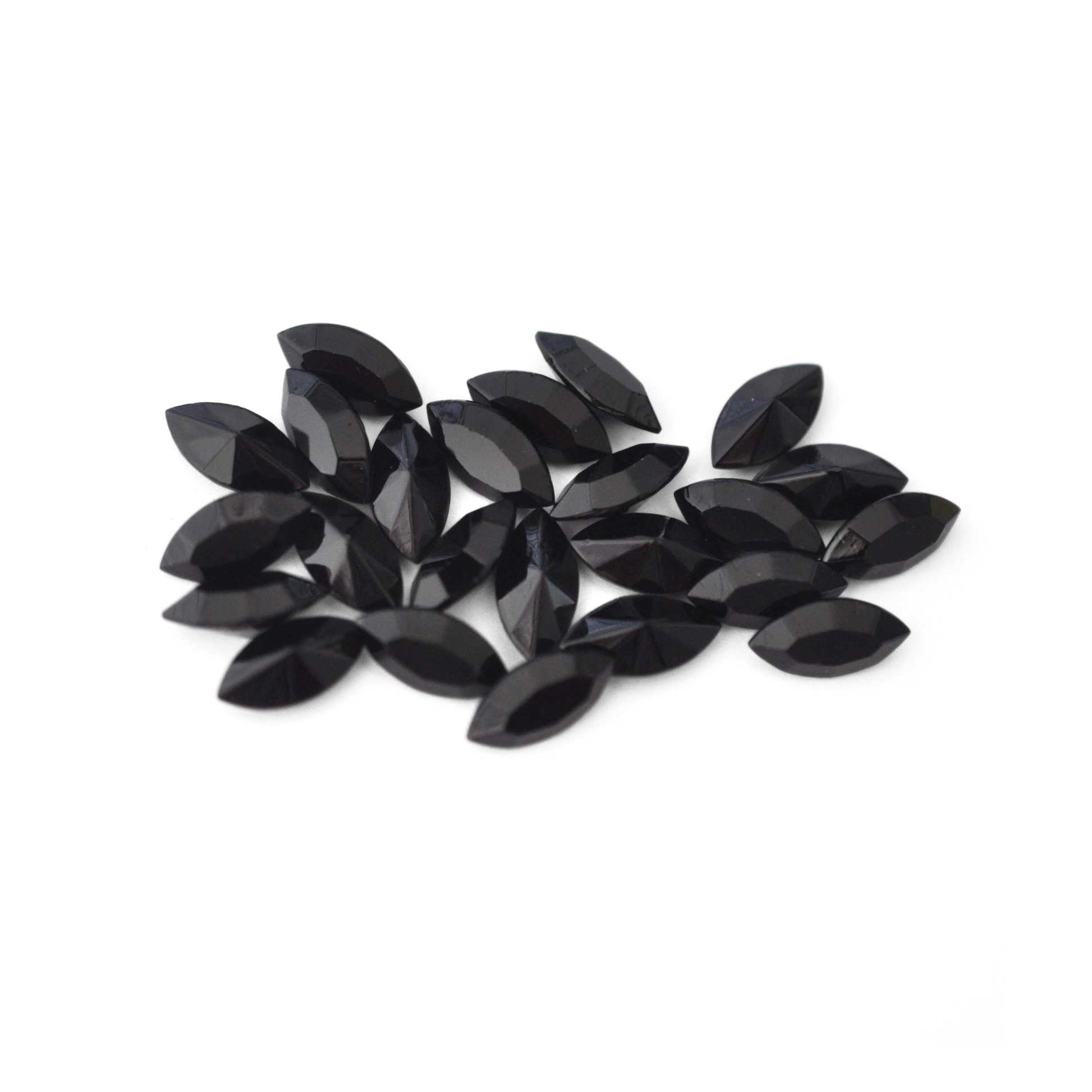 Navette shaped faceted Austrian crystal rhinestones in the color Jet displayed on a white background.