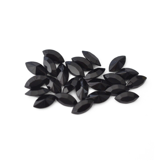 Navette shaped faceted Austrian crystal rhinestones in the color Jet displayed on a white background.