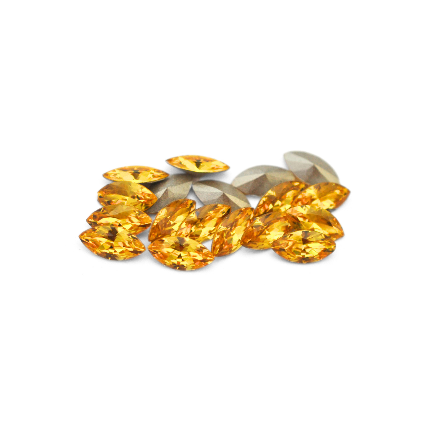 Navette shaped faceted Austrian crystal rhinestones in the color Light Topaz displayed on a white background.