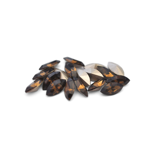 Navette shaped faceted Austrian crystal rhinestones in the color Smoky Quartz displayed on a white background.