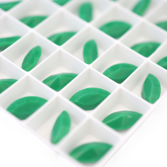 Navette shaped faceted Austrian crystal rhinestones in the color Apple Green displayed on a white background.