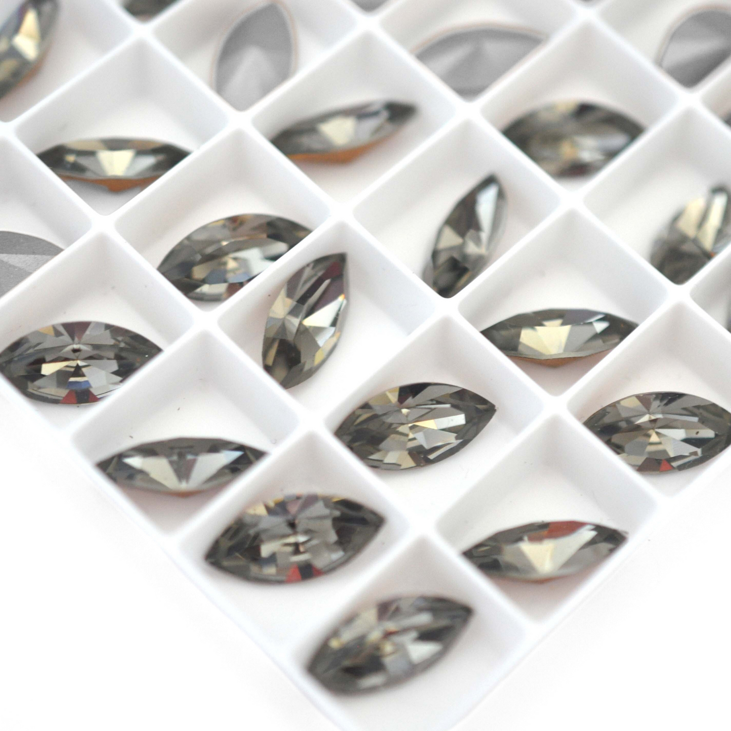 Navette shaped faceted Austrian crystal rhinestones in the color Black Diamond displayed on a white background.