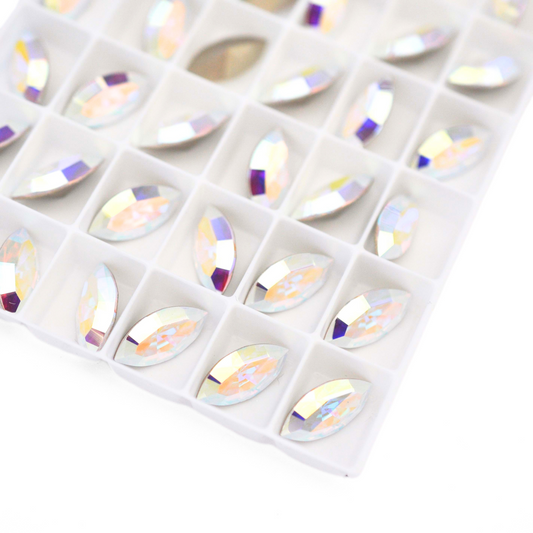 Navette shaped faceted Austrian crystal rhinestones in the color Crystal AB displayed on a white background.