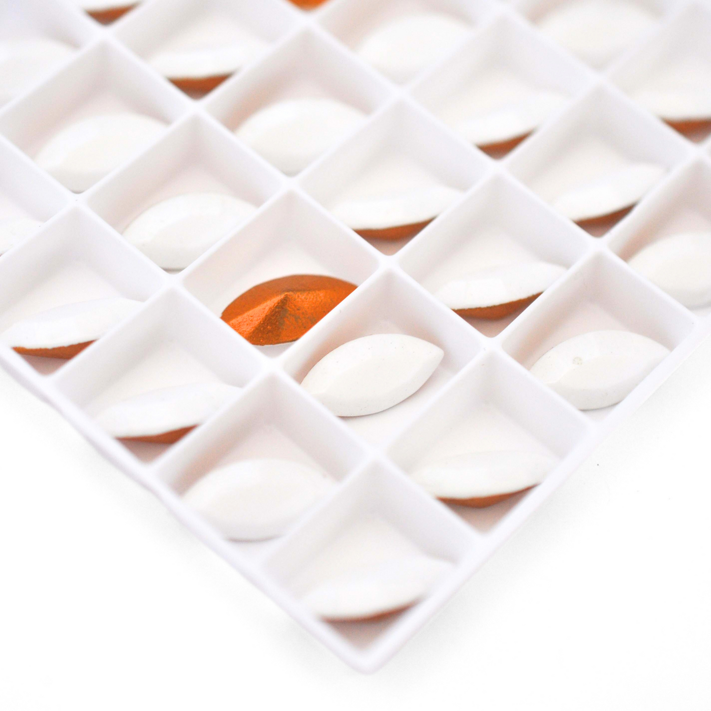 Navette shaped faceted Austrian crystal rhinestones in the color Chalk White displayed on a white background.