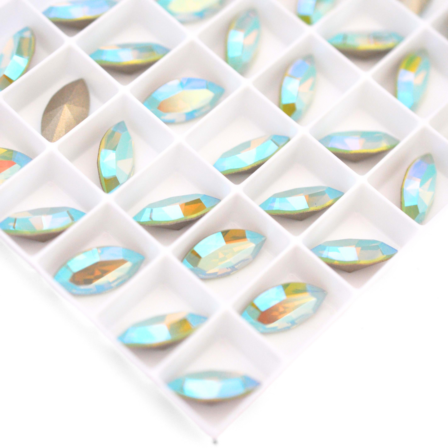 Navette shaped faceted Austrian crystal rhinestones in the color Chrysolite Opal Shimmer displayed on a white background.