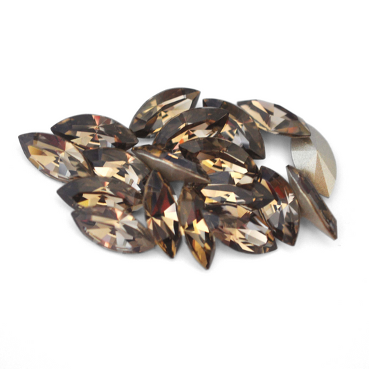 Navette shaped faceted Austrian crystal rhinestones in the color Greige displayed on a white background.