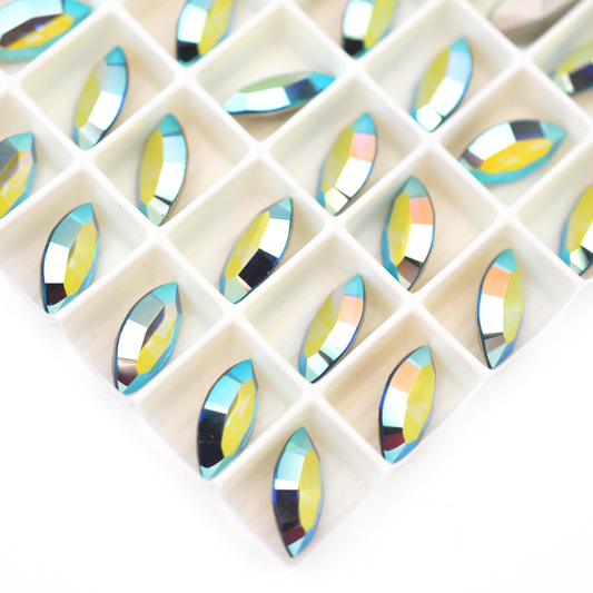 Navette shaped faceted Austrian crystal rhinestones in the color Indicolite AB displayed on a white background.