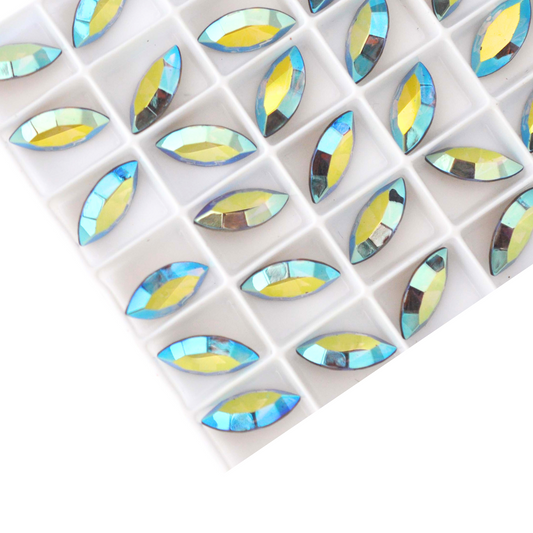 Navette shaped faceted Austrian crystal rhinestones in the color Light Colorado Topaz AB displayed in a tray on a white background.