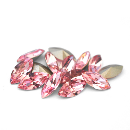 Navette shaped faceted Austrian crystal rhinestones in the color Light Rose displayed on a white background.