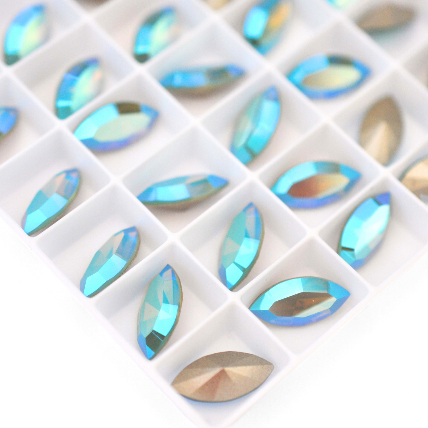 Navette shaped faceted Austrian crystal rhinestones in the color Pacific Opal Shimmer displayed on a white background.