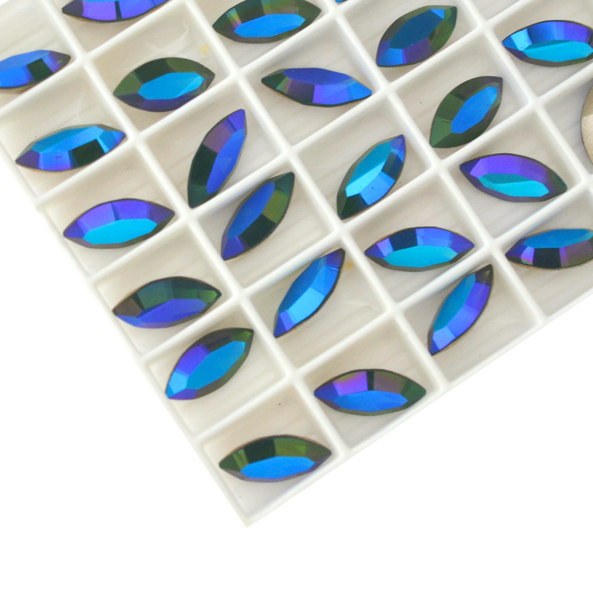 Navette shaped faceted Austrian crystal rhinestones in the color Palace Green Opal Glacier Blue displayed in a tray on a white background.