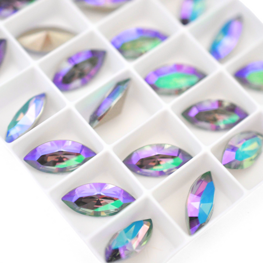 Navette shaped faceted Austrian crystal rhinestones in the color Paradise Shine displayed on a white background.