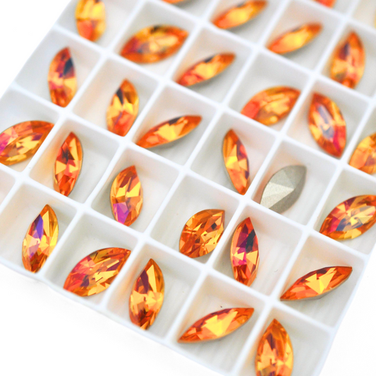 Navette shaped faceted Austrian crystal rhinestones in the color Summer Blush displayed on a white background.