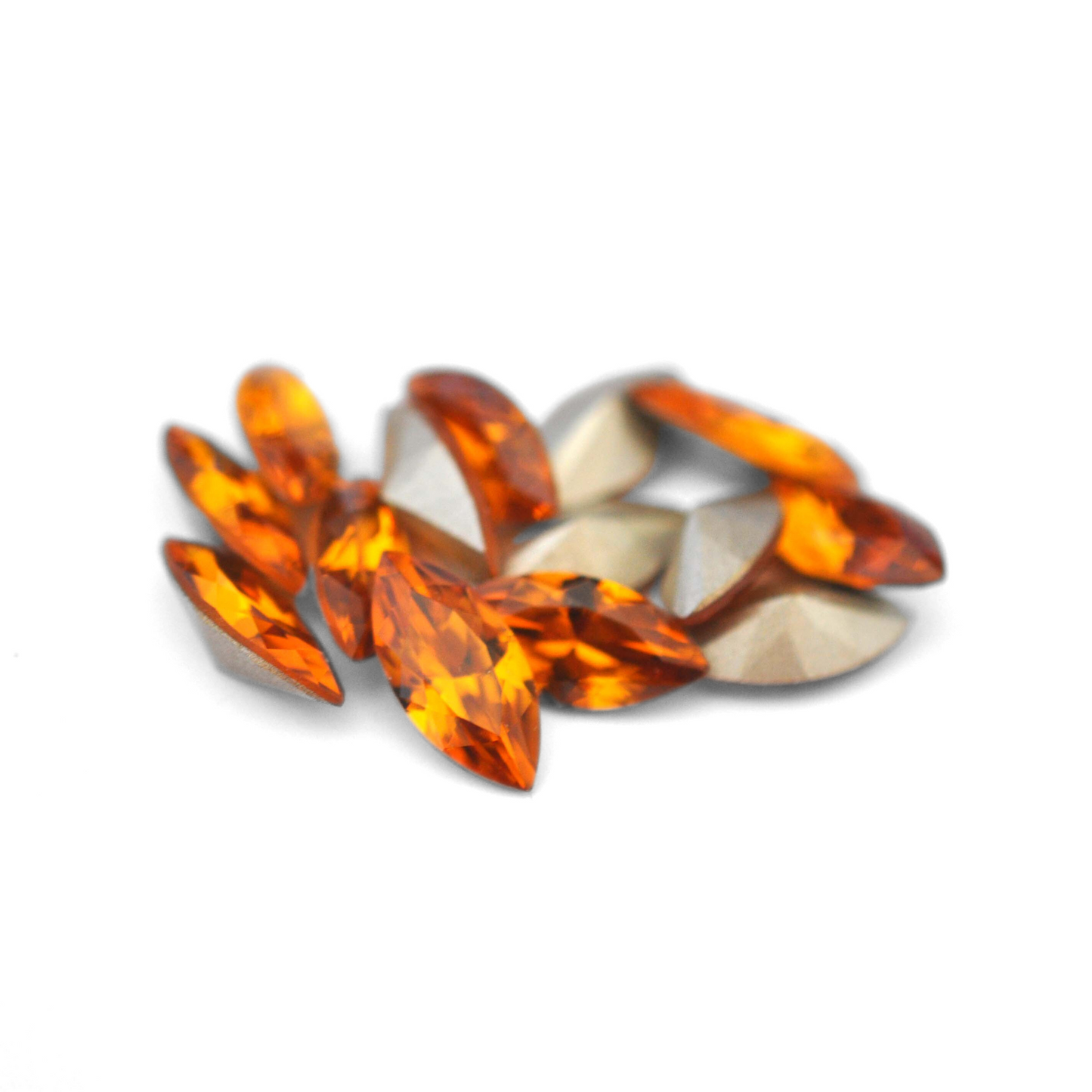 Navette shaped faceted Austrian crystal rhinestones in the color Topaz displayed on a white background.