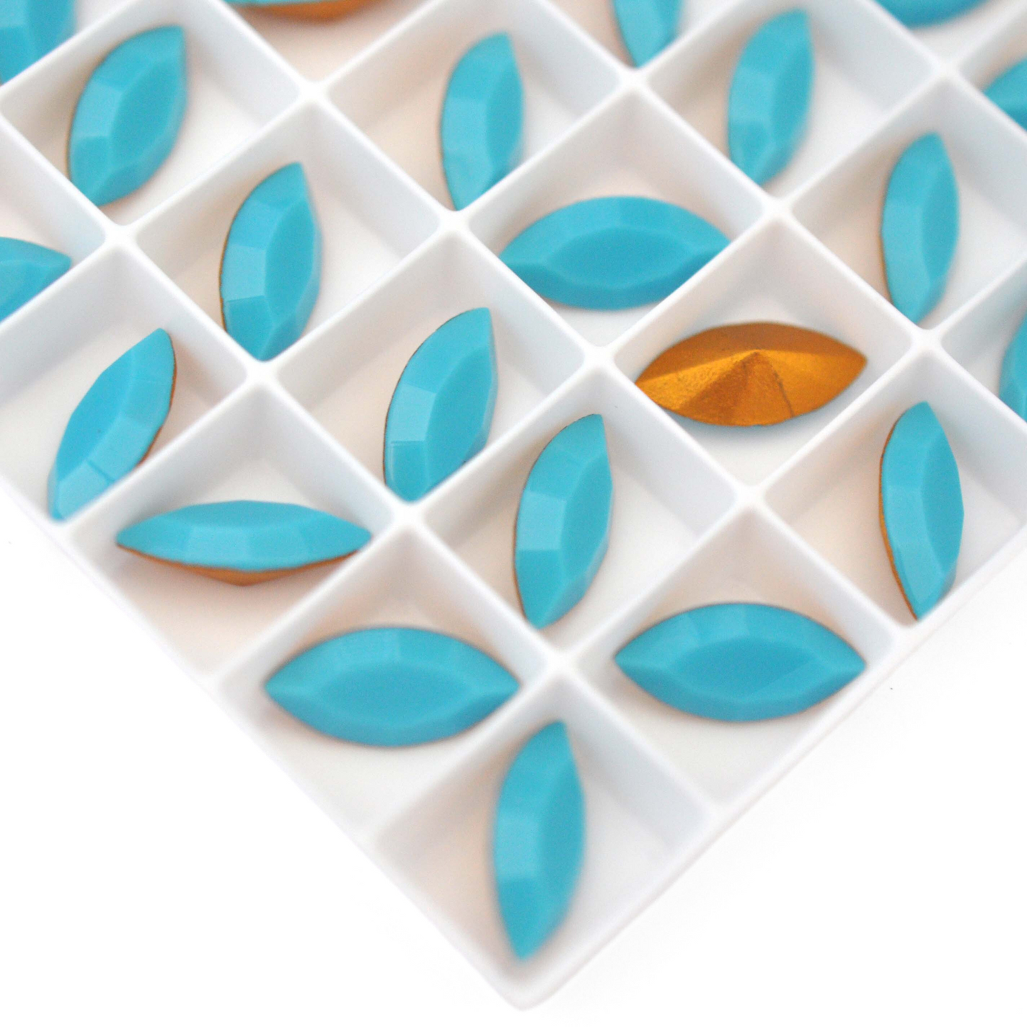 Navette shaped faceted Austrian crystal rhinestones in the color Turquoise displayed on a white background.