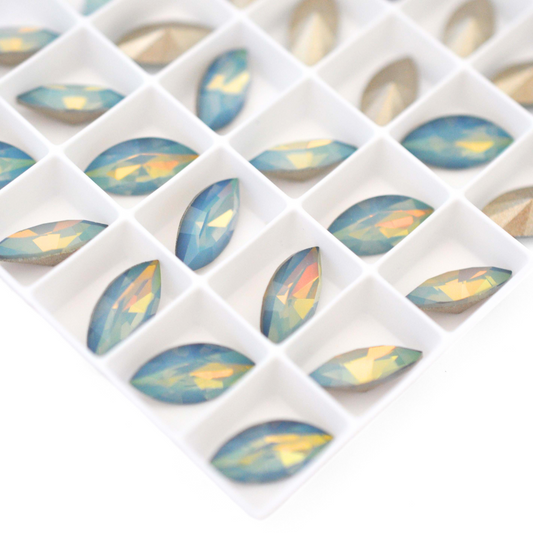 Navette shaped faceted Austrian crystal rhinestones in the color White Opal Star Shine displayed on a white background.