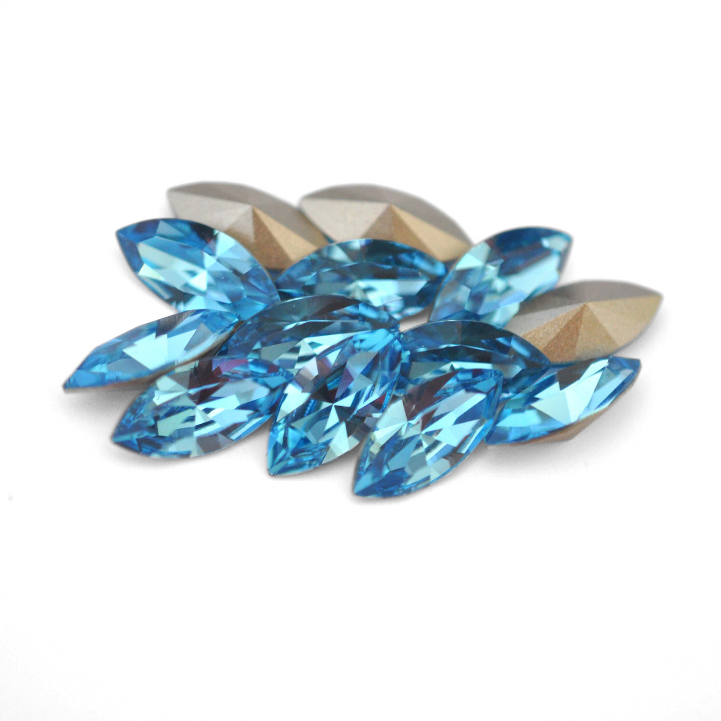 Navette shaped faceted Austrian crystal rhinestones in the color Aquamarine displayed on a white background.