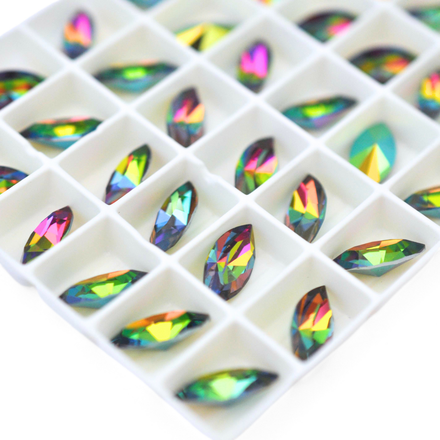 Navette shaped faceted Austrian crystal rhinestones in the color Iridis displayed on a white background.