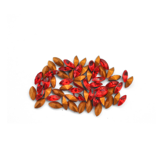 Navette shaped faceted Austrian crystal rhinestones in the color Light Siam displayed on a white background.