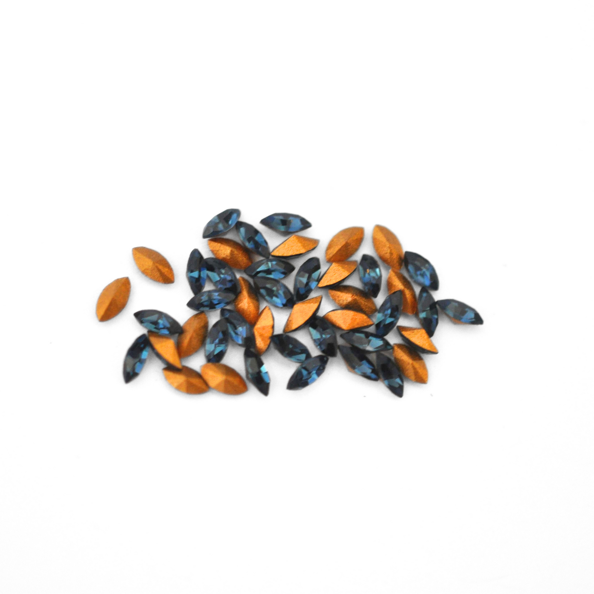 Navette shaped faceted Austrian crystal rhinestones in the color Montana displayed on a white background.