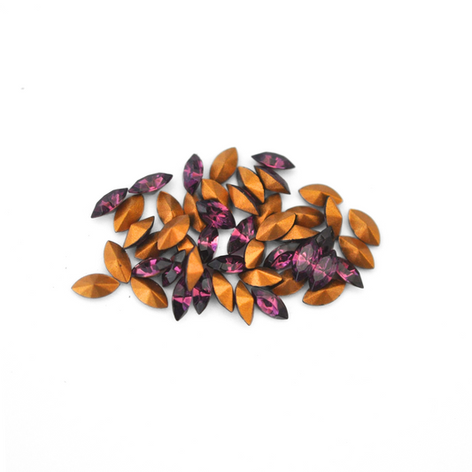 Navette shaped faceted Austrian crystal rhinestones in the color Amethyst displayed on a white background.