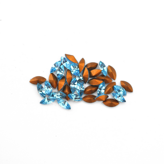 Navette shaped faceted Austrian crystal rhinestones in the color Aquamarine displayed on a white background.