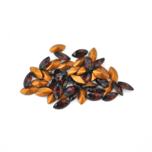 Navette shaped faceted Austrian crystal rhinestones in the color Burgundy displayed on a white background.