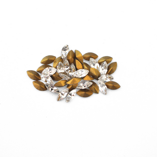 Navette shaped faceted Austrian crystal rhinestones in the color Crystal displayed on a white background.