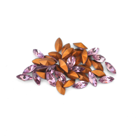 Navette shaped faceted Austrian crystal rhinestones in the color Light Amethyst displayed on a white background.