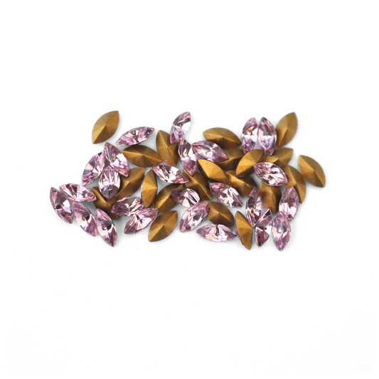 Navette shaped faceted Austrian crystal rhinestones in the color Light Amethyst displayed on a white background.