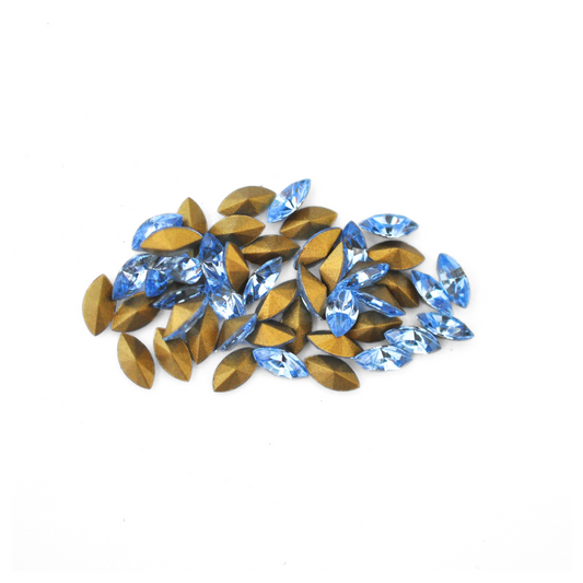 Navette shaped faceted Austrian crystal rhinestones in the color Light Sapphire displayed on a white background.