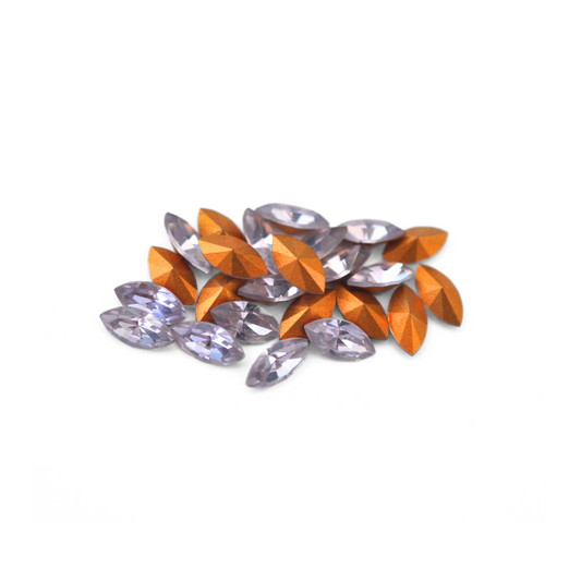 Navette shaped faceted Austrian crystal rhinestones in the color Alexandrite displayed on a white background.