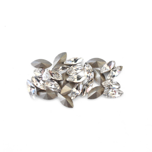 Navette shaped faceted Austrian crystal rhinestones in the color Crystal displayed on a white background.