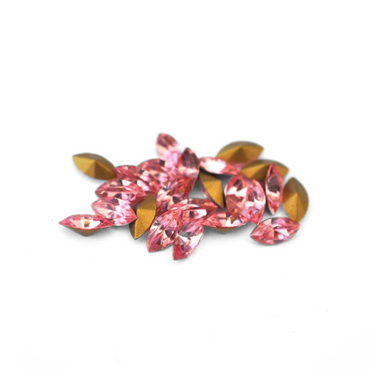 Navette shaped faceted Austrian crystal rhinestones in the color Light Rose displayed on a white background.